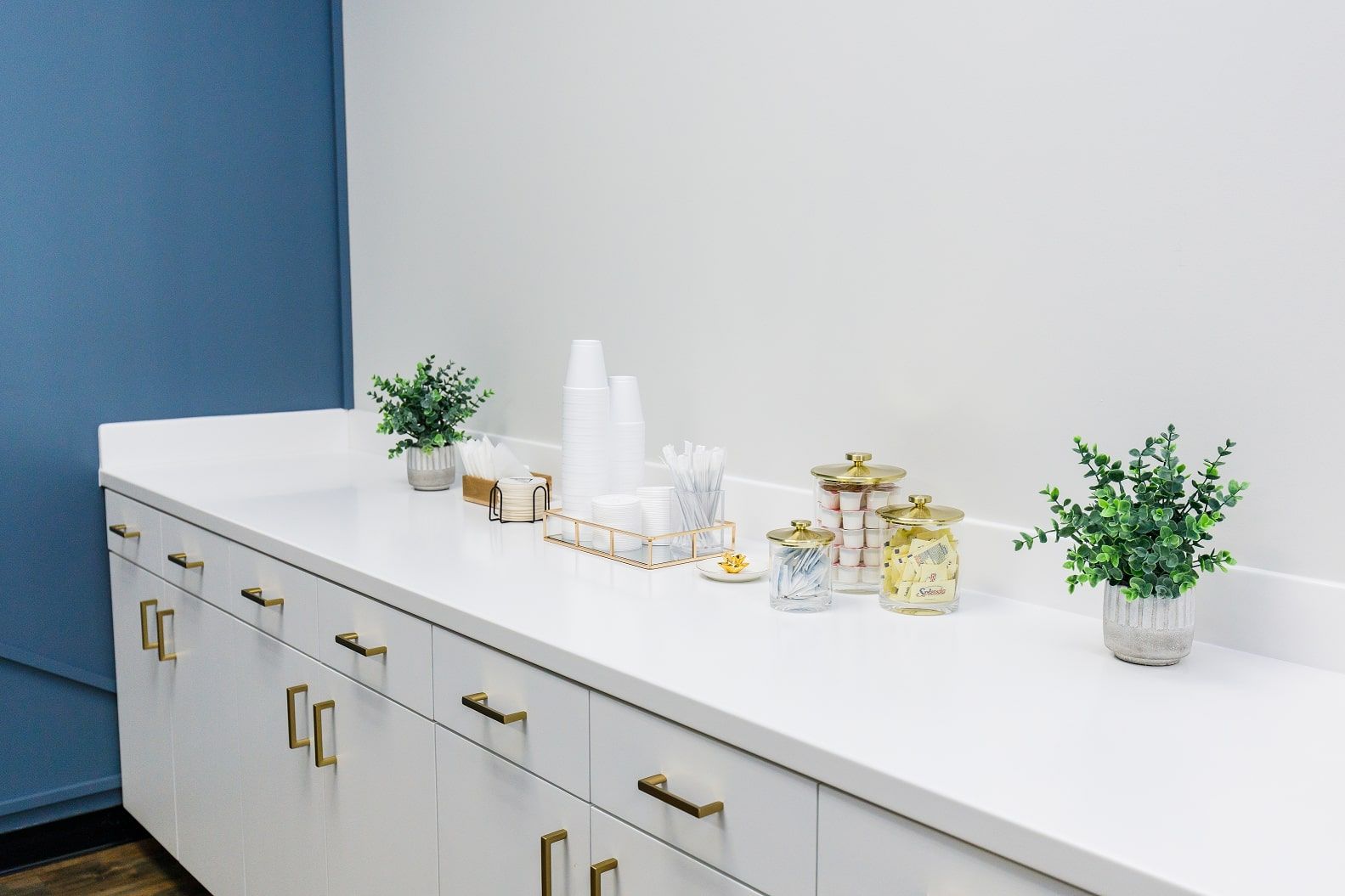 Coffee bar including creamer, sugar, cups and stirring sticks